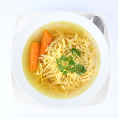 Chicken soup with macaroni and carrots and  a spoon