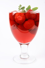 Jelly with strawberries decorated with a lemon balm twig