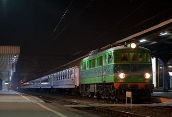 Fototapeta premium Passenger train waiting at the station platform during the night