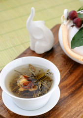 Tied green tea blossoms in a tea cup