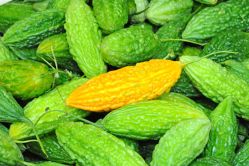 A Ripe Bitter Gourd And A Background Of Green  Gourds
