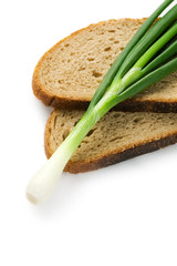 Spring onions and bread isolated on white