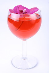 Glass of pink wine decorated with a violet orchid flower