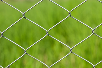 Wire fence on green grass background