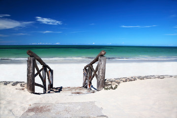 Fototapeta premium Old wooden stairs leading on white sandy beach