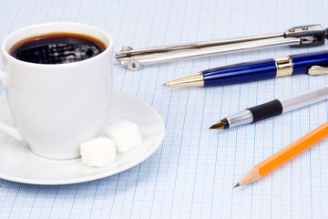 coffee and pens at paper