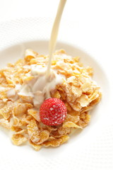 poured milk into the bowl of cornflakes