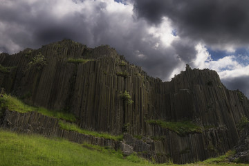 basaltfelsen steinorgel mit gewitterwolken