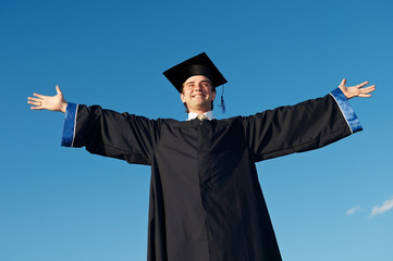 graduate with open arms outdoors