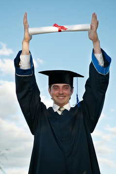 graduate with diploma in hands over head