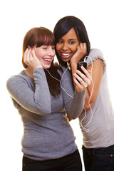 Zwei Frauen hören Musik mit einem Handy