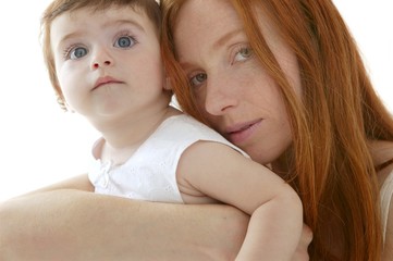 baby and redhead mother hug on white