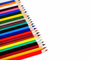 set of multicolored pencils lies on a white background