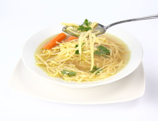 Chicken soup with macaroni, some of it on a spoon