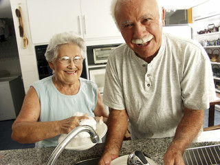 Abuelos lavando platos.
