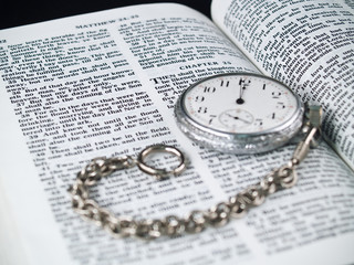 The Bible opened to Matthew 24: 36 with a Pocketwatch