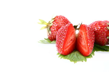 Strawberries on a leaf, one cut in half with space for text