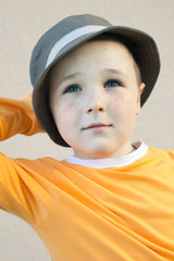 The nice little boy with freckles wearing a hat