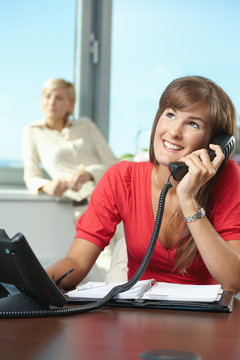 Businesswoman talking on landline phone
