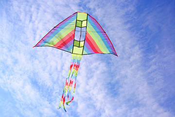 bright multicolored kite in blue cloudy sky