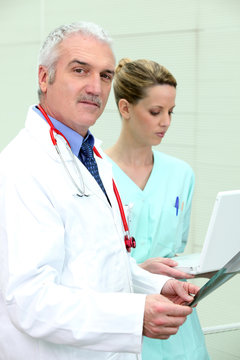 Médecin et assistante devant ordinateur portable