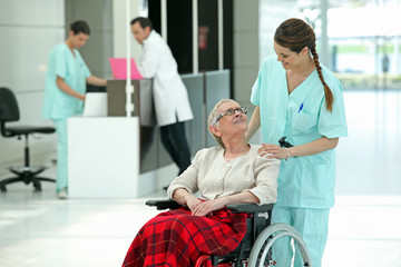 Closeup of a young nurse near an elderly woman in wheelchair