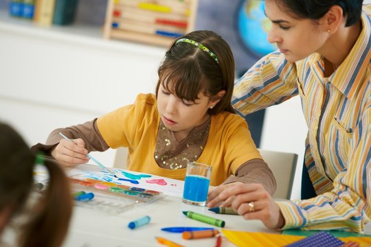 School children and teacher in art class