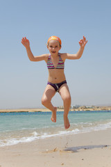 little girl jumping over the water