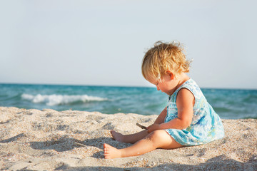 Fototapeta na wymiar cute toddler girl playing on beach