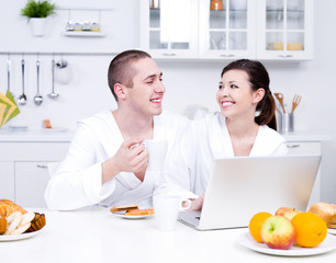 Loving couple with laptop in the kitchen