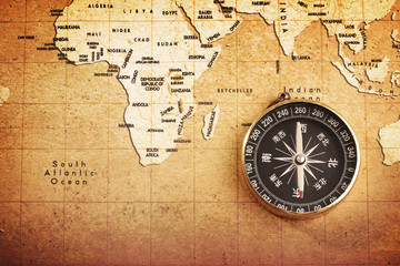 Fototapeta na wymiar An old brass compass on a Treasure map background