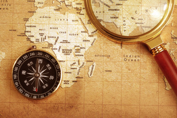 Fototapeta na wymiar compass on a Treasure map background ,with Magnifier