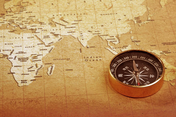 Fototapeta na wymiar An old brass compass on a Treasure map background