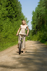 Naklejka premium young female riding a bike in nature
