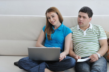 young couple working on laptop at home