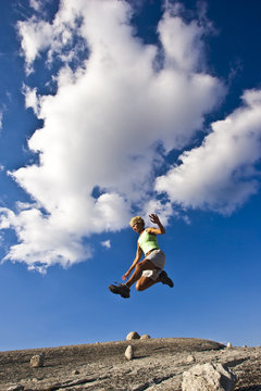 Female trail runner jumping.