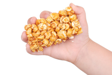 Children hand with sweet popcorn in honey