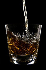 Whiskey being poured in crystal glass