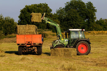 Obraz premium tractor loading hay bay bale