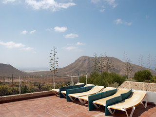 Fototapeta premium Beach chairs against blue sky and mountains