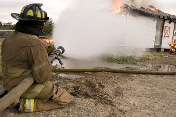 Fireman sprays burning building