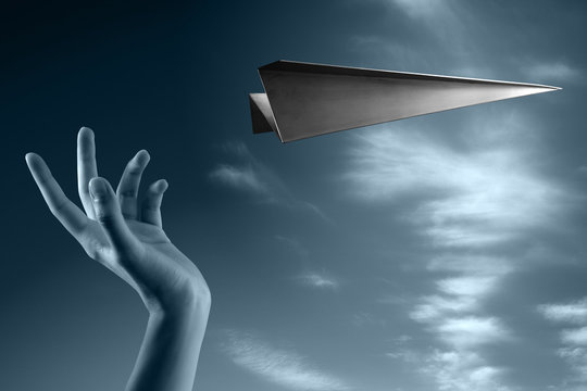 mano che lancia un aereo in acciaio