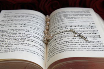 Rosenkranz auf einem Gesangbuch