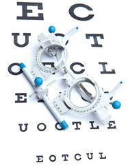 optometry concept - sight measuring spectacles & eye chart
