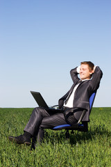 Young businessman on a green field