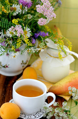 Field flowers and chamomile tea (background)