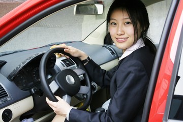 A beautiful Asian  business woman with her red car