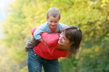 Fototapeta premium happy mother playing with son outdoors