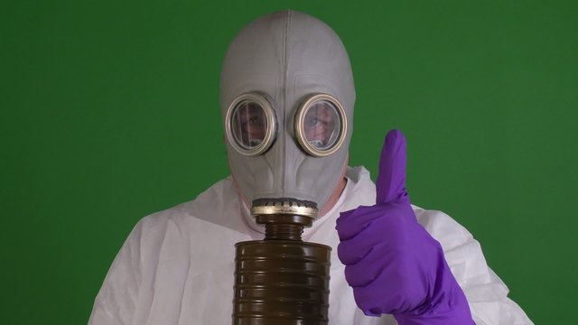man in gas mask signals thumbs up