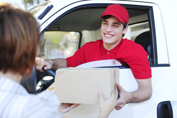 postal delivery courier in a van delivering package